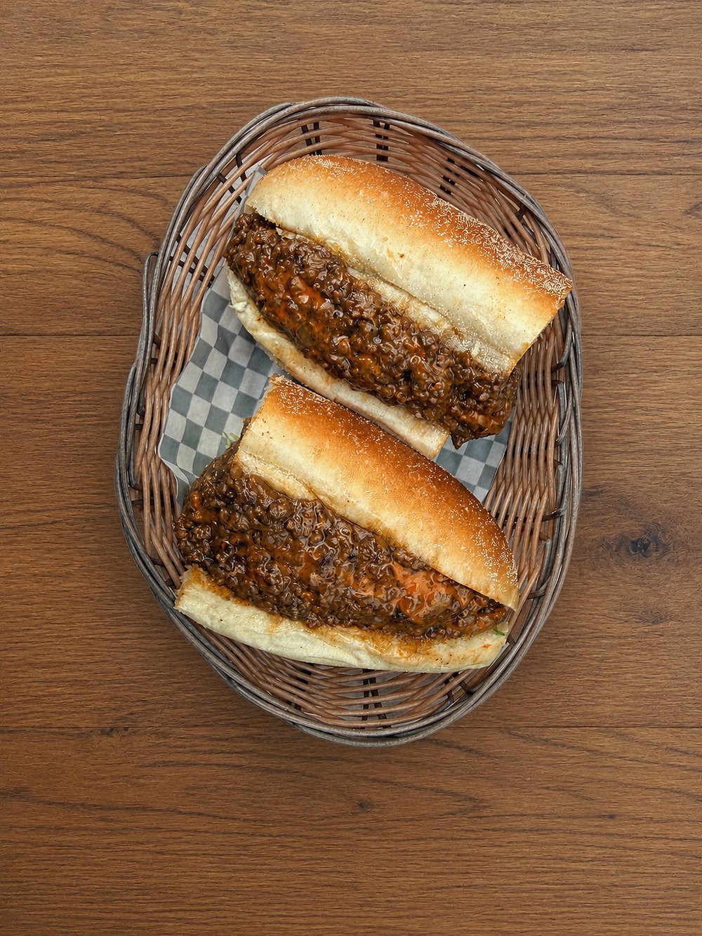 Chopped meat sub sliced in half in a basket